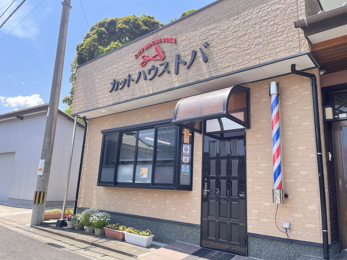 店舗の外観。「カットハウストバ」の看板と、入口横の赤白青のサインポール
